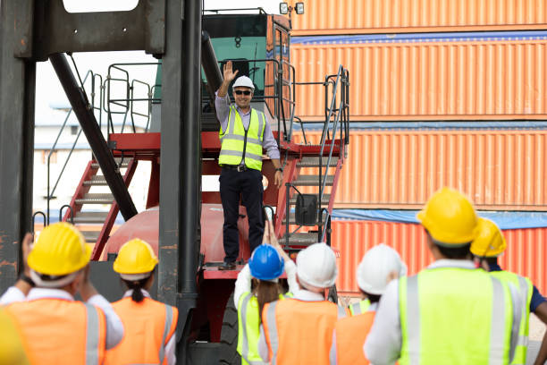 istock warehouse boss engineer standing on crane car with factory workers raise hand for congratulations in containers warehouse storage 1323138302