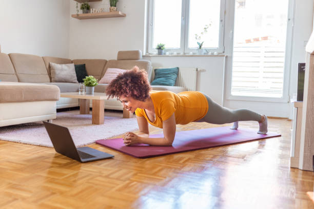 istock Young woman doing plank exercise at home 1323138531