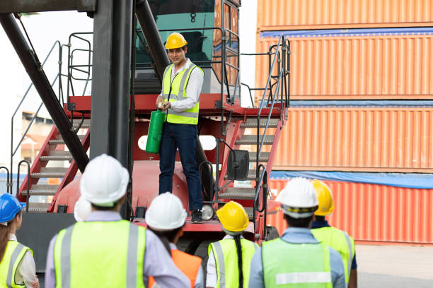 istock male engineer standing on crane car using fire extinguisher with factory workers in containers warehouse storage 1323138667