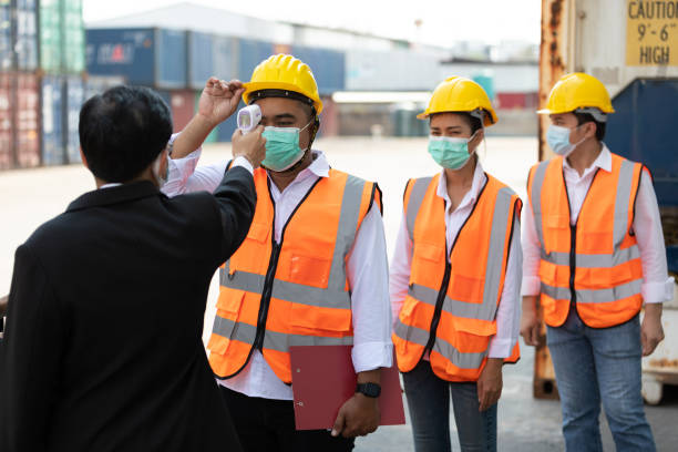 istock foreman scanning fever temperature with digital thermometer to workers in construction site 1323139433