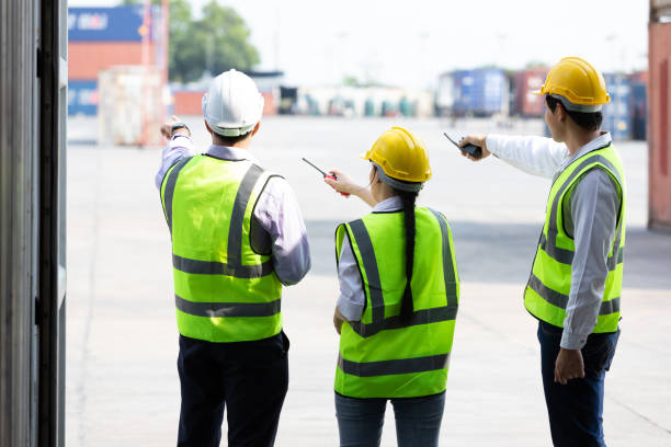 istock back view shot factory workers or engineers talking and planing for a job in containers warehouse storage 1323140312
