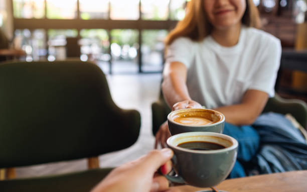 istock a man and a woman clinking coffee mugs in cafe 1323142550