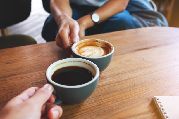 istock a woman and a man clinking coffee cups together in cafe 1323142956