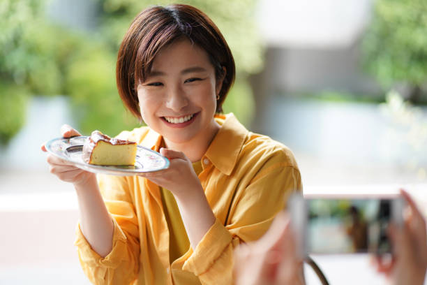 istock Woman holding a cake and taking a picture 1323143961