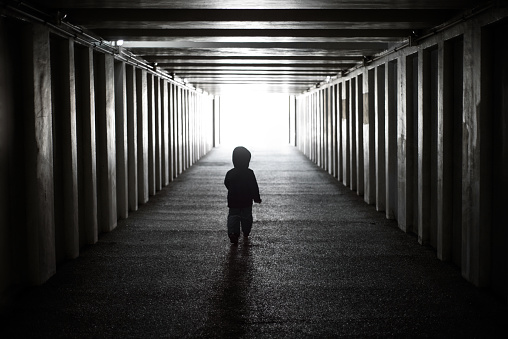 The child goes from darkness to light. Dangerous walks through the dark tunnel
