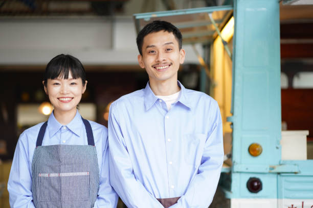 una pareja de pie frente a un coche de cocina - café edificio de hostelería fotografías e imágenes de stock