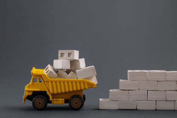 istock Yellow Dump Truck on grey background. Delivery Building Material. Transportation, Construction industry 1323148072