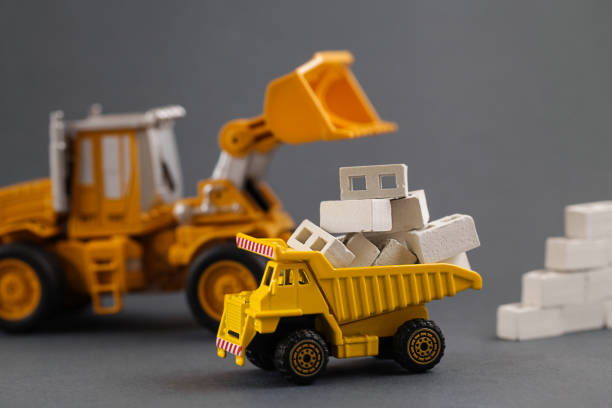 istock Yellow Dump Truck, Excavator, Loading Building Materials on Dark grey Background. Delivery Building Material. Rent Construction Equipment. construction industry 1323148113