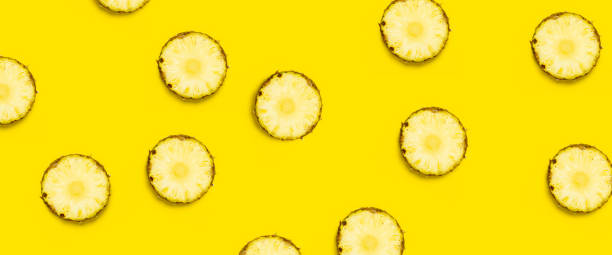 istock Round pineapple slices on a yellow background. Top view, flat lay. Banner 1323153236