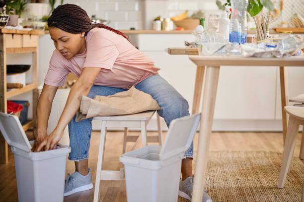 istock Woman sorting waste into the different garbage bins at home 1323154214