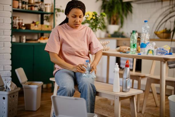 istock Woman sorting waste into the different garbage bins at home 1323154274