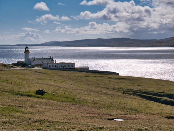 Designed by brothers David and Thomas Stevenson, Bressay Lighthouse on a sunny day, with sunlight on Bressay Sound in the background.