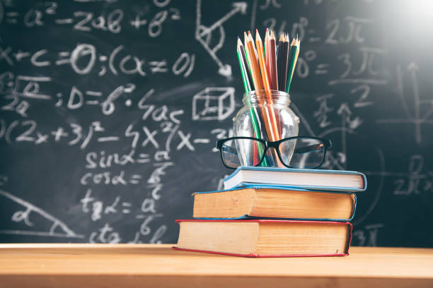 istock color pencils  and glasses on book with blackboard 1323157494
