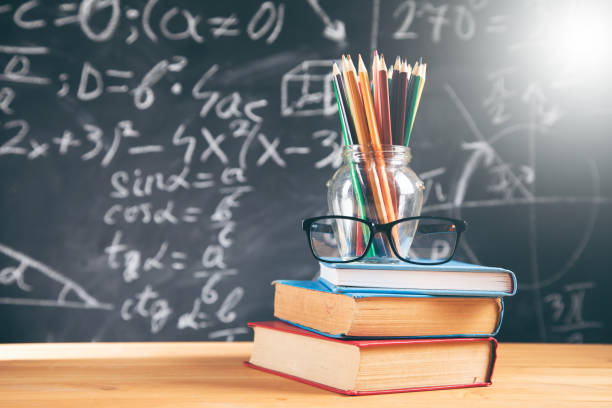 istock color pencils  and glasses on book with blackboard 1323157498