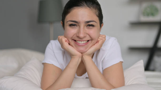 istock Young Indian Woman Smiling at Camera in Bed 1323158796