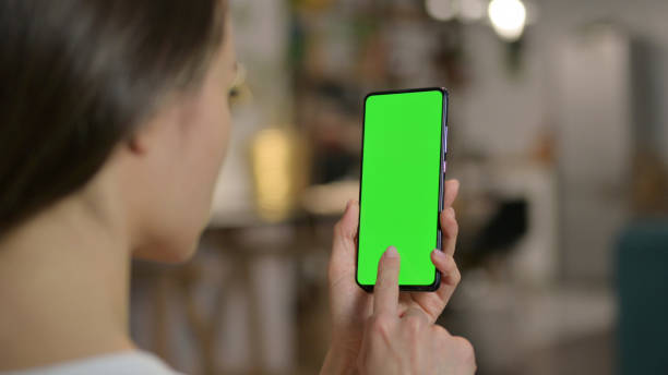 istock Woman Using Smartphone with Green Chroma Screen 1323159391