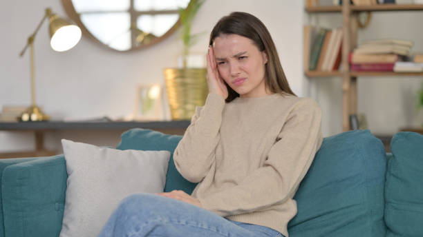 istock Stressed Young Woman with Headache on Sofa 1323159661