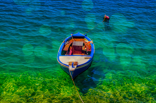 A little fisherman boat standing at sea during hot summer day.