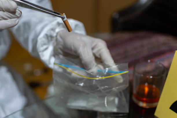 istock Forensic scientist, looking for the evidence on the crime scene, collecting fingerprints, photographing evidence, with his full protective suit, gloves, and forensic gear. 1323160073