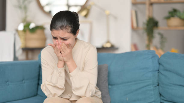 istock Young Indian Woman Sitting and Crying on Sofa 1323161724