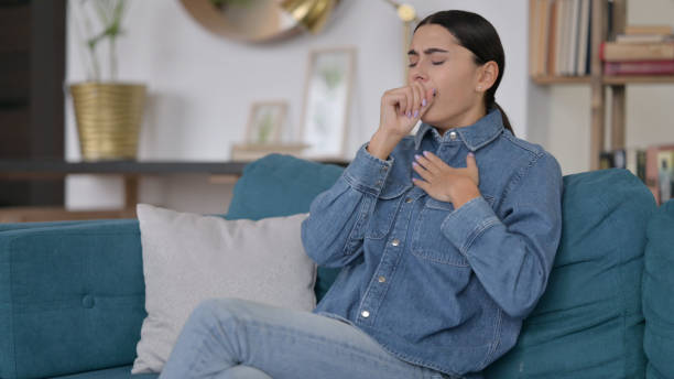 istock Sick Latin Woman Coughing on Sofa 1323162042