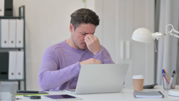 istock Middle Aged Man with Laptop having Headache in Office 1323162240