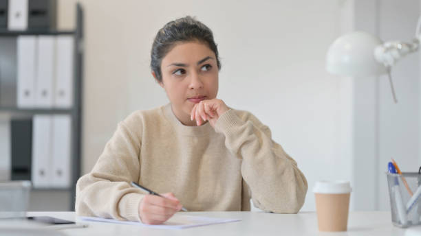 pensive młoda indyjska kobieta pisanie na papierze - women pensive indian culture mature adult zdjęcia i obrazy z banku zdjęć