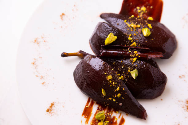 istock Pears cooked in red wine served with pistachios. 1323163078