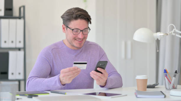 istock Online Shopping Success on Smartphone by Middle Aged Man 1323163097