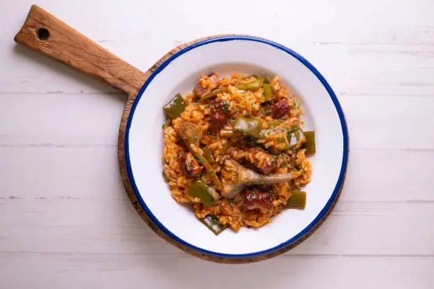 Spanish paella with rabbit, sausages, vegetables and artichokes. Traditional recipe from the Mediterranean area.