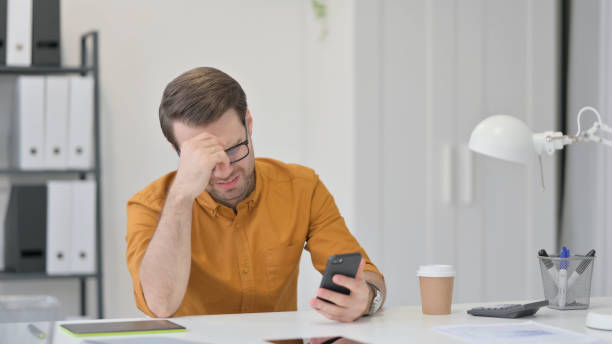 istock Young Man Reacting to Loss on Smartphone 1323163441