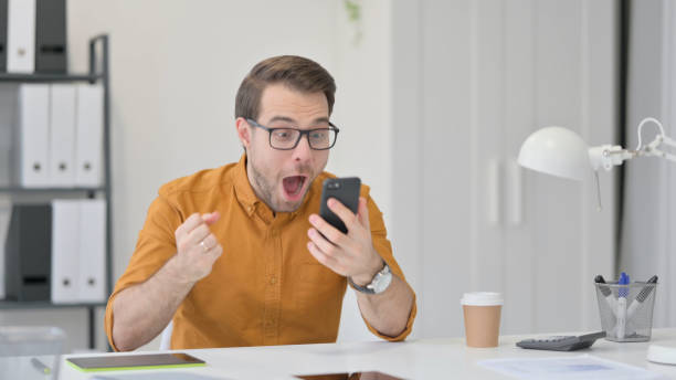 istock Excited Man Celebrating Success on Smartphone 1323163581