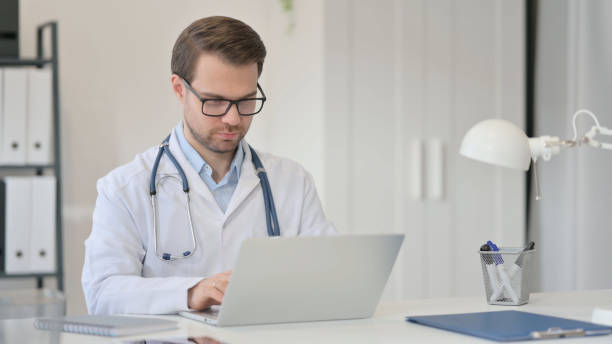 istock Male Doctor Working on Laptop in Office 1323163853