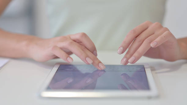 istock Close Up of Female Hands Typing on Tablet 1323164577