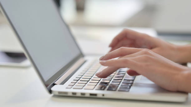 istock Female Hands Typing on Laptop, Side View 1323164654