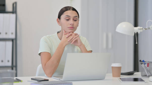 istock Young Latin Woman Thinking at Work 1323164684