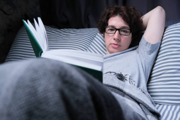 istock Mature woman is reading in bed 1323164806