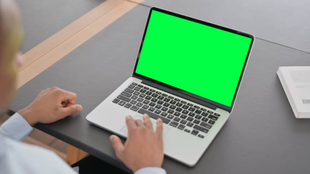 istock African Man using Laptop with Green Chroma Key Screen 1323164949