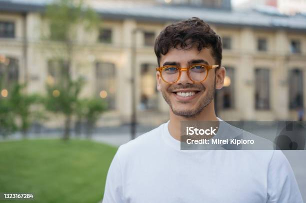 Young Successful Indian Man Wearing Stylish Eyeglasses Standing On The Street Handsome Asian Model Posing For Pictures Looking At Camera Smiling Stock Photo - Download Image Now