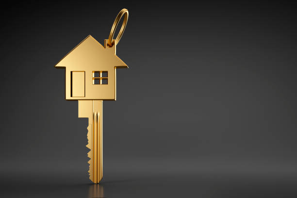 Golden house key Golden house shaped key on dark background house key photos stock pictures, royalty-free photos & images