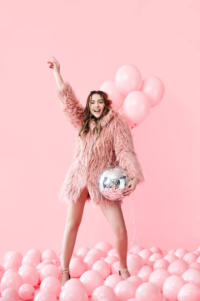 Trendy young woman have fun with party disco ball on pink balloons background Trendy young woman have fun with party disco ball on pink balloons background. Emotions, celebrate concept evening ball photos stock pictures, royalty-free photos & images