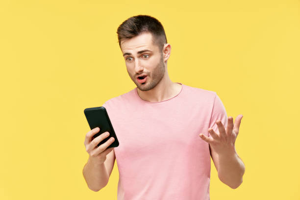 istock Shocked funny millennial man using mobile phone 1323169205