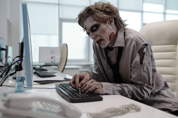 Ugly man with zombie makeup working with computer Ugly man with zombie makeup working with computer in office zombie computer stock pictures, royalty-free photos & images
