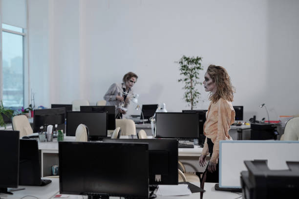 Zombie female moving along rows of desks in open space office