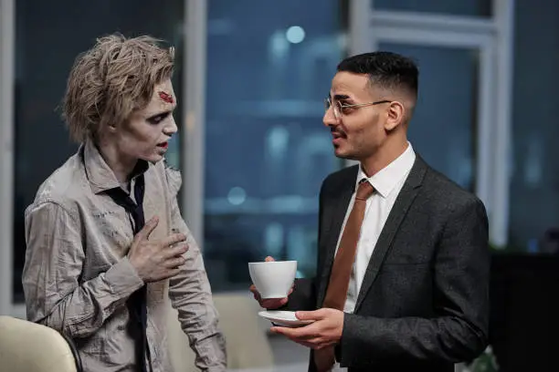 Zombie man talking to contemporary manager with drink in office environment