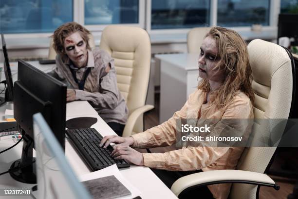 Gloomy Businesswoman With Zombie Greesepaint Using Computer Stock Photo - Download Image Now