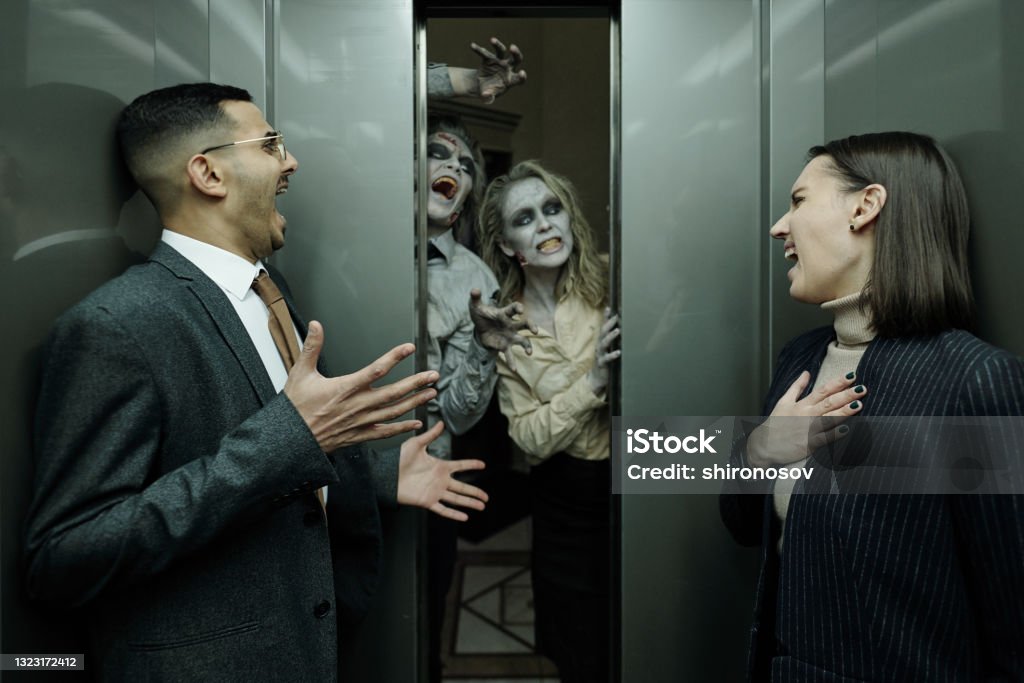 Two terrified managers screaming in elevator while zombies frightening them Terrified office managers screaming in elevator while zombies frightening them Zombie Stock Photo