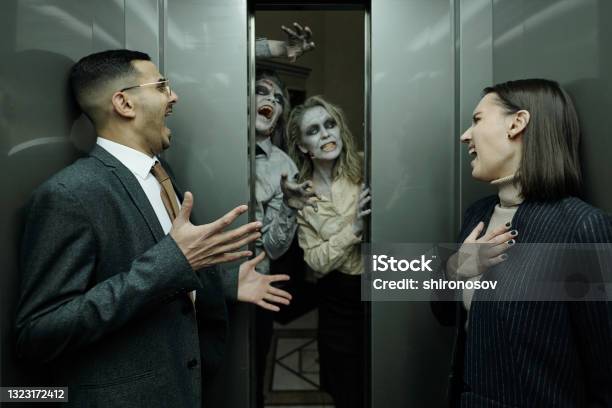 Two Terrified Managers Screaming In Elevator While Zombies Frightening Them Stock Photo - Download Image Now