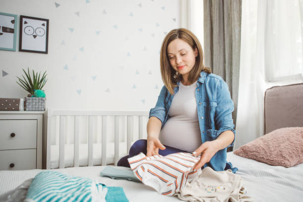 istock Pregnant woman arranging clothes 1323178739