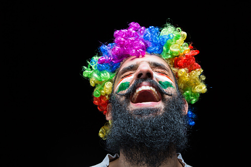 closeup of a creepy bald evil clown, standing in front of a dirty and old circus tent, wearing a gray costume with a white ruff, and starring at the observer with a frightening smile